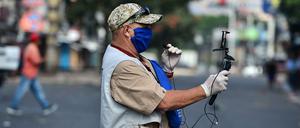 Ein Journalist in Tegucigalpa, der Hauptstadt von Honduras, trägt eine Gesichtsmaske und Handschuhe. 