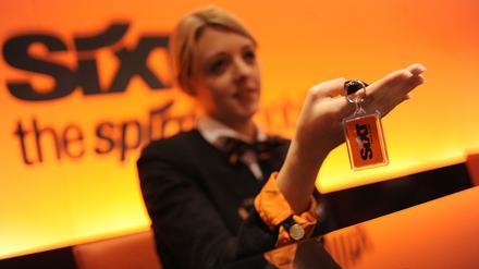 Eine Mitarbeiterin des Autovermieters Sixt übergibt in einer Filiale den Schlüssel für einen Mietwagen.