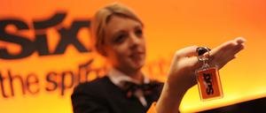 Eine Mitarbeiterin des Autovermieters Sixt übergibt in einer Filiale den Schlüssel für einen Mietwagen.