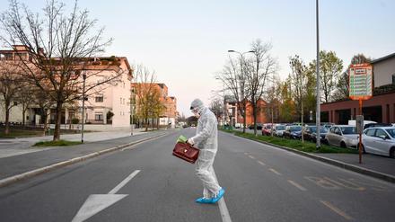 Ein medizinischer Mitarbeiter geht in Bergamo über die Straße.