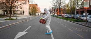 Ein medizinischer Mitarbeiter geht in Bergamo über die Straße.