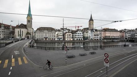 Ein Radfahrer fährt einsam durch die leeren Straßen von Zürich.
