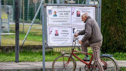 Ein Passant hält an den öffentlichen Todesanzeigen in einer Gemeinde der Lombardei.
