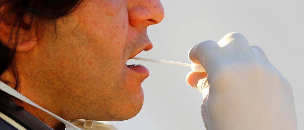Ein Patient nimmt sich selbst einen Abstich für den Coronavirus-Test.
