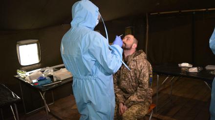 An der Front in der Donbass-Region wird ein ukrainischer Soldat auf Covid-19 getestet.