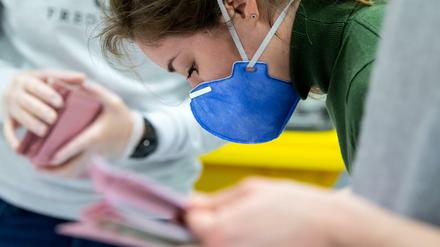 Kommunalwahl in Bayern: Eine Wahlhelferin in München mit Schutzmaske