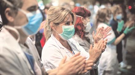 Abwehrzauber. Das Personal einer Klinik in Barcelona bedankt sich klatschend für den Applaus aus der Stadt.