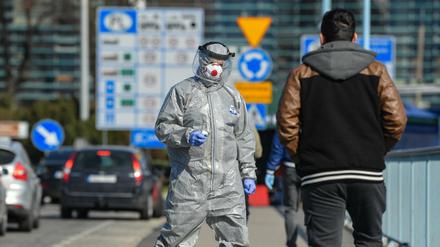 Kontrolle: Ein Mann in Schutzanzug mit einem Thermometer am deutsch-polnischen Grenzübergang von Frankfurt (Oder)