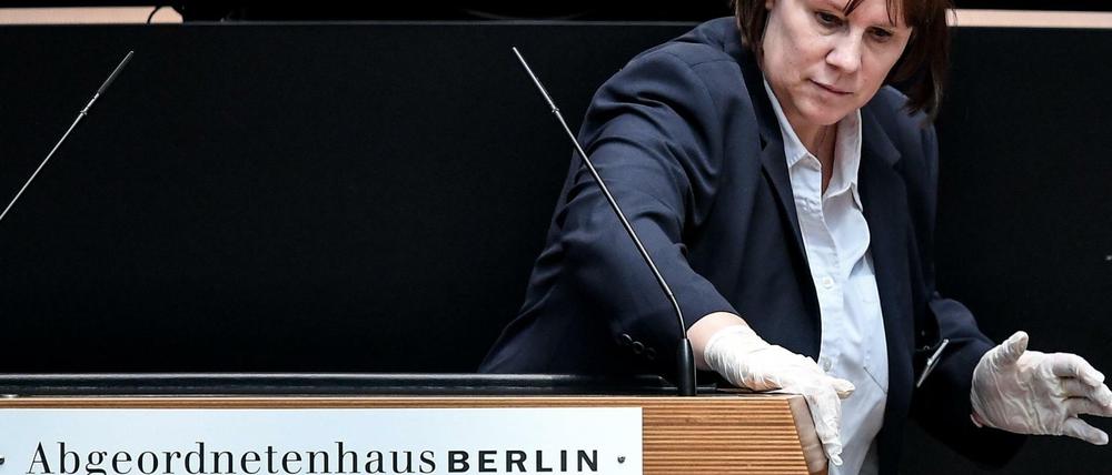 Stille Heldin: Eine Mitarbeiterin reinigte bei der Plenarsitzung am Donnerstag nach jedem Redebeitrag das Pult im Abgeordnetenhaus.