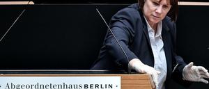 Stille Heldin: Eine Mitarbeiterin reinigte bei der Plenarsitzung am Donnerstag nach jedem Redebeitrag das Pult im Abgeordnetenhaus.