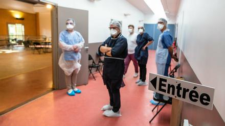 Medizinische Mitarbeiter mit Mundschutzmasken arbeiten in einem provisorischen medizinischen Zentrum.