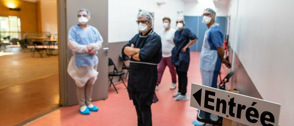 Medizinische Mitarbeiter mit Mundschutzmasken arbeiten in einem provisorischen medizinischen Zentrum.