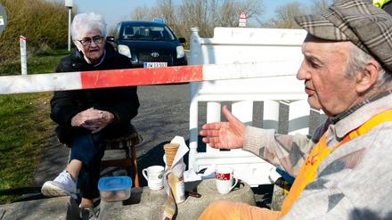 Karsten Tüchsen Hansen (rechts) und die Dänin Inga Rasmussen sitzen am deutsch-dänischen Grenzübergang.