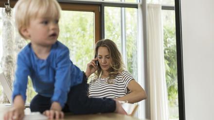 Gleichzeitig arbeiten und auf die Kinder aufpassen. Eine Mutter mit Ihrem Sohn.