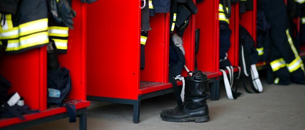 Firefighter clothing hangs in several lockers.