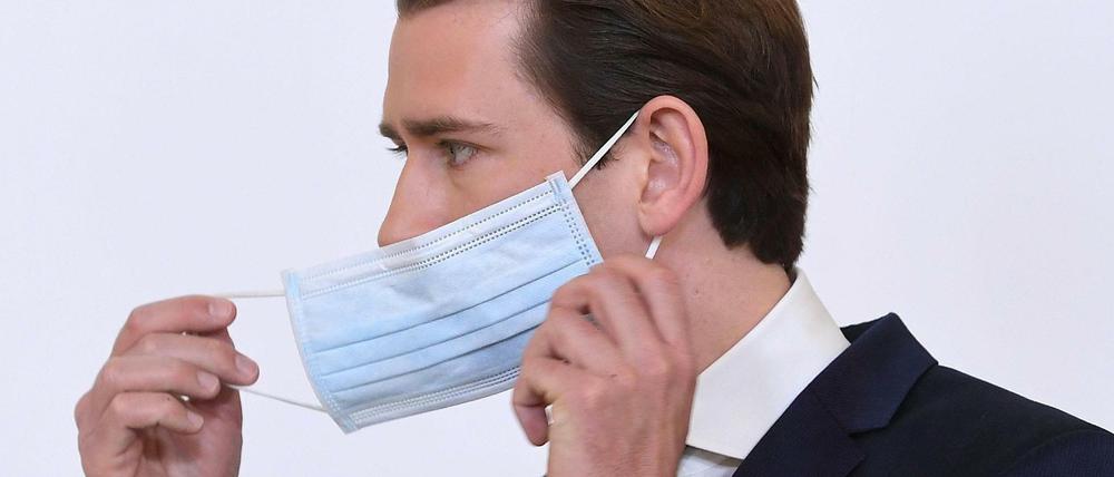 Österreichs Bundeskanzler Sebastian Kurz nimmt seine Schutzmaske ab.