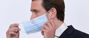 Österreichs Bundeskanzler Sebastian Kurz nimmt seine Schutzmaske ab.