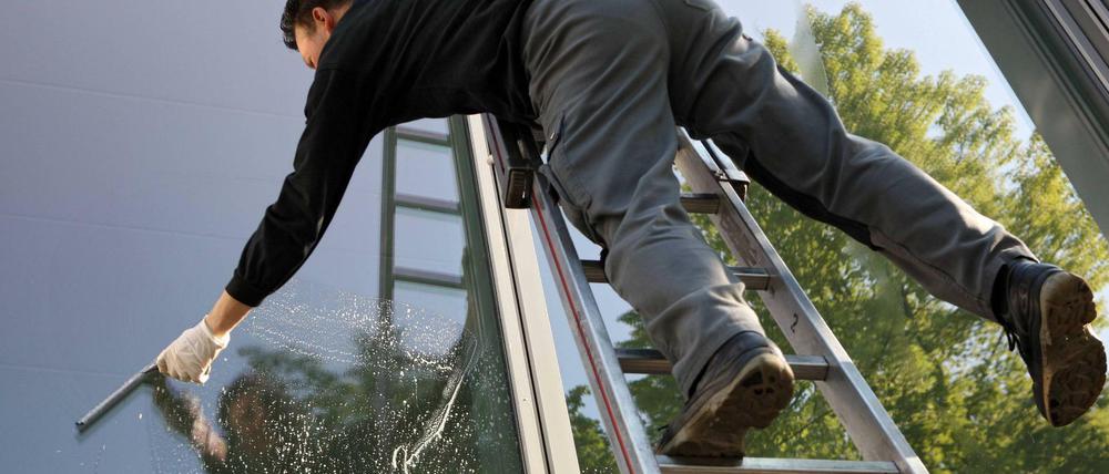 Fensterputzer bei der Arbeit. Sie arbeiten oft unter dem Mindestlohn.