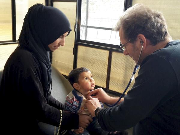 Gerhard Trabert untersucht  im Flüchtlingslager Ayn Issa im Norden von Syrien einen kleinen Jungen.