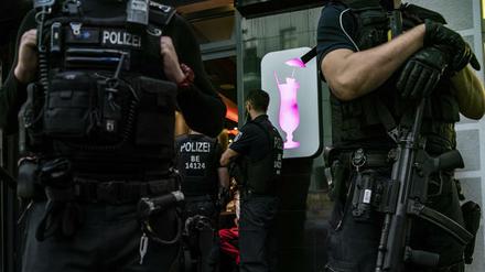 Polizeibeamte stehen bei einer großen Kontrollaktion in Neukölln vor einem gastronomischen Betrieb. 