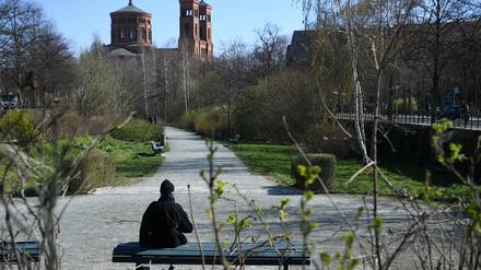 Auf der Parkbank in der Sonne sitzen – wie diese Frau in Kreuzberg – ist nun wieder erlaubt.