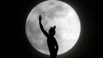 Der Mond ist hinter einer Statue auf der Spitze eines Hotelturms in Nashville in den USA zu sehen.