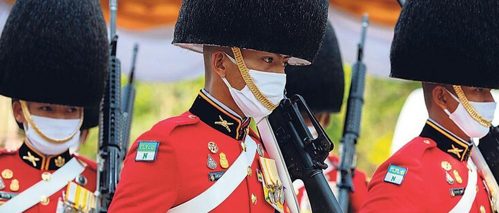 Ohne Maske kein Dienst in der thailändischen Ehrenwache. Und in Europa geht man ohne immer seltener auf die Straße.