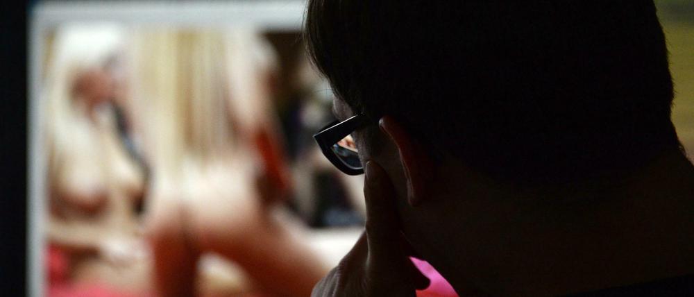 Ein Mann schaut sich auf einem Computer einen Porno an. Dass schon Zehnjährige im Netz ungehindert harte Pornografie konsumieren können, wollen Medienaufseher in Deutschland nicht länger hinnehmen. Nun legen sie sich mit den Großen der Branche an.