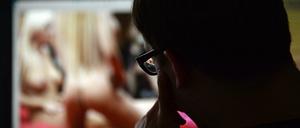 Ein Mann schaut sich auf einem Computer einen Porno an. Dass schon Zehnjährige im Netz ungehindert harte Pornografie konsumieren können, wollen Medienaufseher in Deutschland nicht länger hinnehmen. Nun legen sie sich mit den Großen der Branche an. 