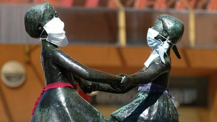 Unbekannte haben den Figuren einer Bronzeplastik in Jena Mundschutz angelegt.