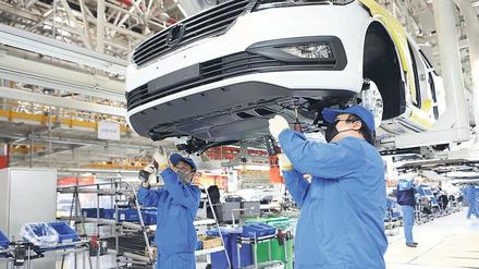 Die Produktion wird langsam hochgefahren. Arbeiter in einem VW-Werk in China.