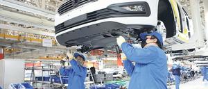 Die Produktion wird langsam hochgefahren. Arbeiter in einem VW-Werk in China.