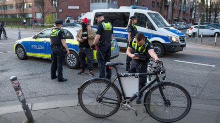 Polizisten in Hamburg kontrollieren einen Demonstranten.