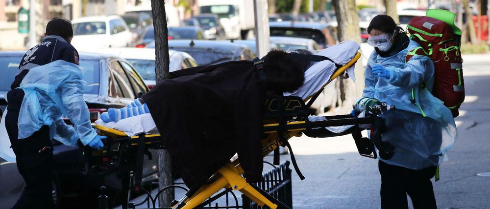 Medizinisches Personal schiebt einen Coronavirus-Patienten in New York zum Rettungswagen.