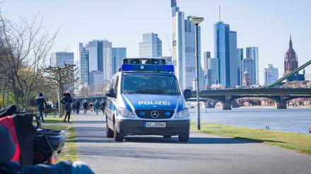 Ein Lautsprecherwagen der Polizei fährt am südlichen Mainufer entlang und macht die Spaziergänger auf die Abstandsregeln aufmerksam.