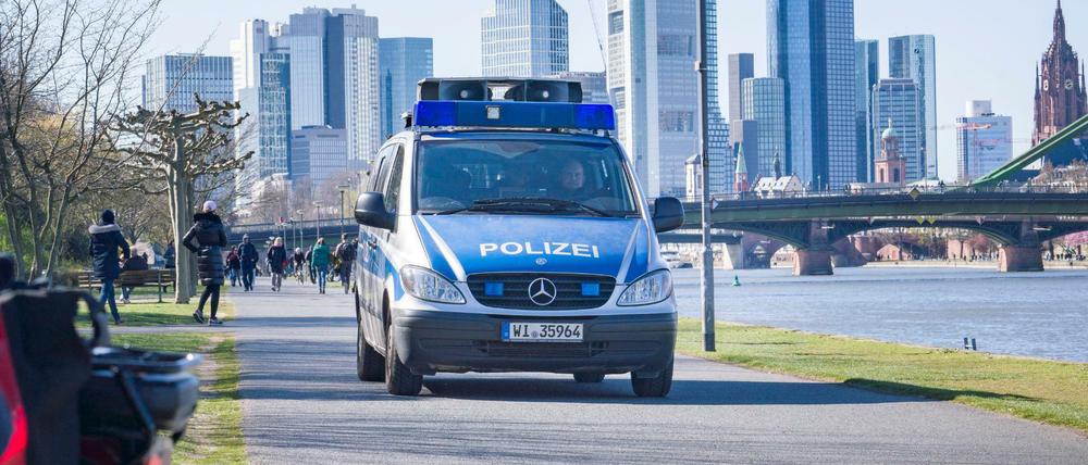 Ein Lautsprecherwagen der Polizei fährt am südlichen Mainufer entlang und macht die Spaziergänger auf die Abstandsregeln aufmerksam.