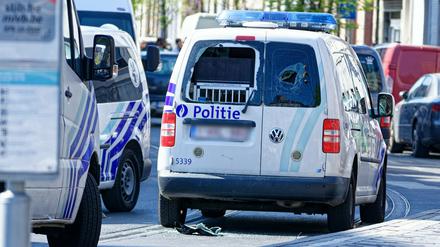 Ein Polizeiauto mit zertrümmerten Heckscheiben steht auf der Straße.