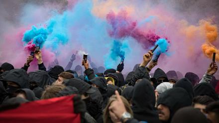 Demonstranten der Revolutionären 1. Mai Demonstration in Berlin Kreuzberg entzünden Rauchtöpfe und Pyrotechnik.
