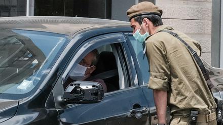 Ein Polizist spricht mit einem Autofahrer in dem Jerusalemer Viertel Givat Mordechai, nachdem in mehreren strengreligiösen Vierteln der Stadt wegen des Corona-Virus weitere Beschränkungen verhängt wurden. 