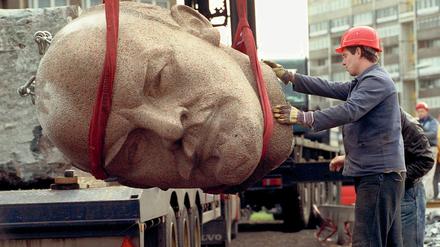 Ein Arbeiter steht am 13.11.1991 während der Abrissarbeiten des ehemaligen Lenindenkmals in Berlin neben dem Kopf des Monuments.