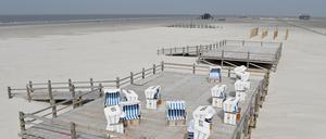 Ungenutzte Strandkörbe stehen auf einer Holzterrasse am Strand von St. Peter Ording.