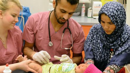 2016 im im Gesundheitszentrum der Landesaufnahmestelle für Flüchtlinge in Halle/Saale: Die damals fünf Monate alte Zeinab, die ihre Mutter Madineh (rechts) auf der Flucht von Afghanistan nach Deutschland im Iran geboren hat, bekommt die Sechsfach-Impfung vom Arzt Nomagy Oweida. 