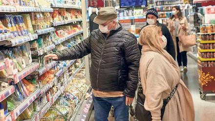 Hinter Masken. Handel, Personal und Kunden tun schon jetzt oft ihr Möglichstes, um sich beim Gang in den Supermarkt nicht mit dem neuartigen Coronavirus zu infizieren.