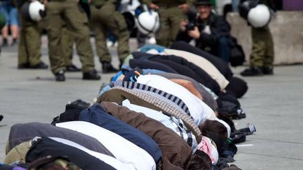 Salafisten beten auf dem Potsdamer Platz, um gegen eine Kundgebung der islamfeindlichen Partei Pro Deutschland zu protestieren.