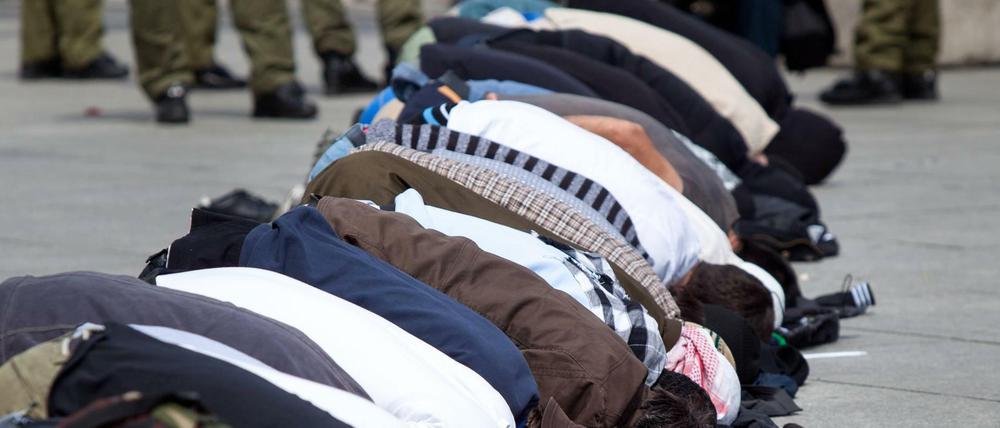 Salafisten beten auf dem Potsdamer Platz, um gegen eine Kundgebung der islamfeindlichen Partei Pro Deutschland zu protestieren.