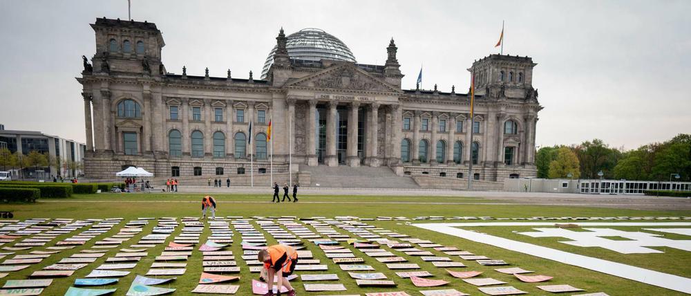 Aktivisten von Fridays for Future legen zu Beginn des alternativen Klimastreiks Protestplakate auf der Reichtagswiese aus.