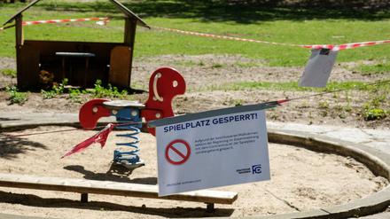 Absperrbänder und ein Schild "Spielplatz gesperrt" auf einem Spielplatz in Berlin-Charlottenburg.