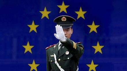 Ein chinesischer Polizist vor der Flagge der Europäischen Union.