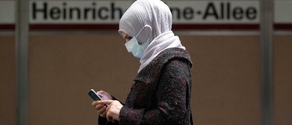 Eine Frau Mundschutz und Smartphone in Düsseldorf
