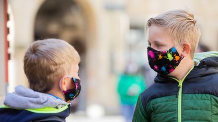 Zwei Jungen tragen auf dem Prinzipalmarkt in Münster eine Mund-Nase-Bedeckung.